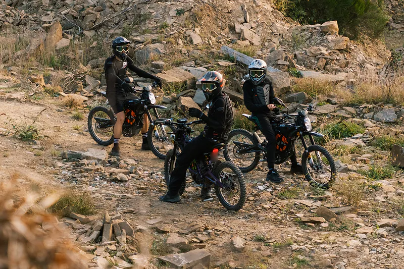 Pilotes en Sur-Ron sur un sentier caillouteux bordé de végétation